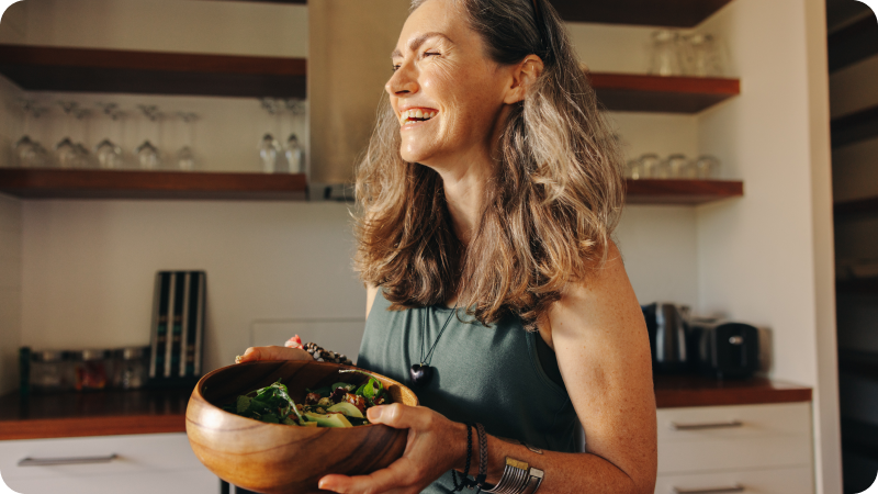 A woman holding a bowl of salad