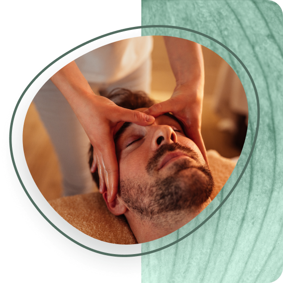 Young man with eyes closed, gets a head massage.