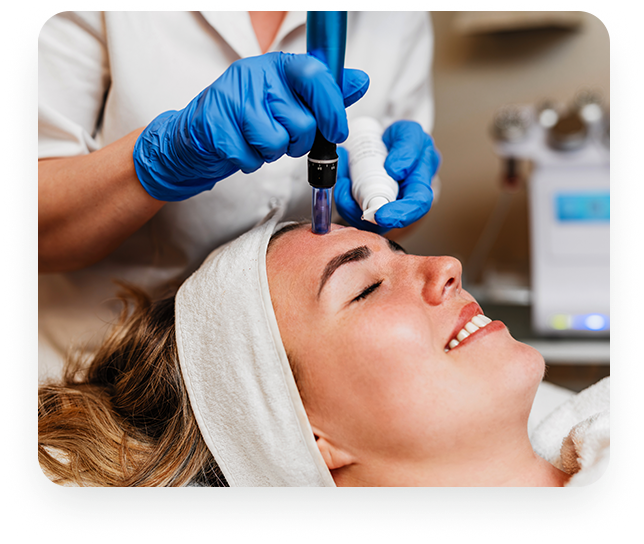 A skincare professional wearing blue gloves performs a microneedling treatment on a woman lying comfortably with a headband.